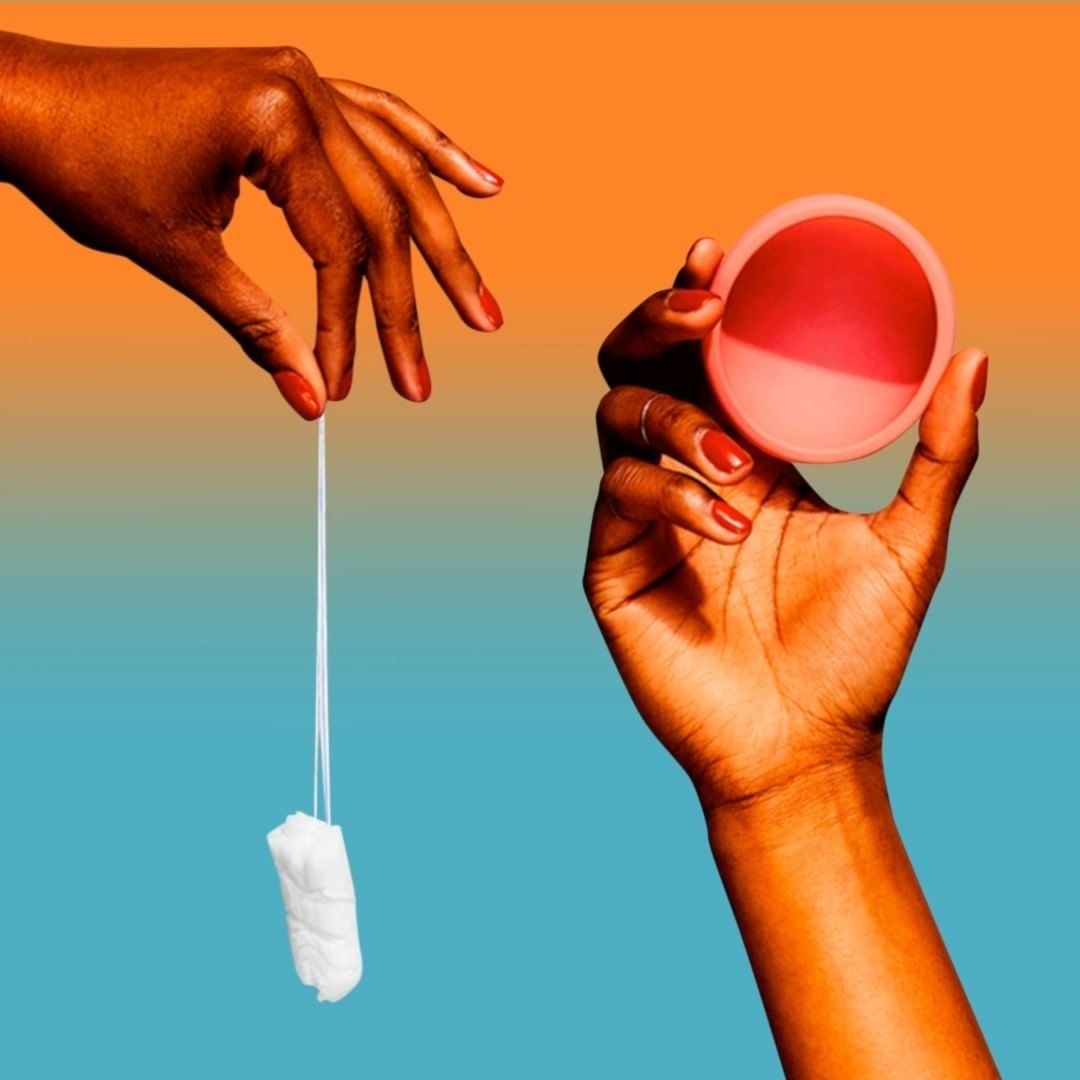A person holding a tampon and a person holding the menstrual disc