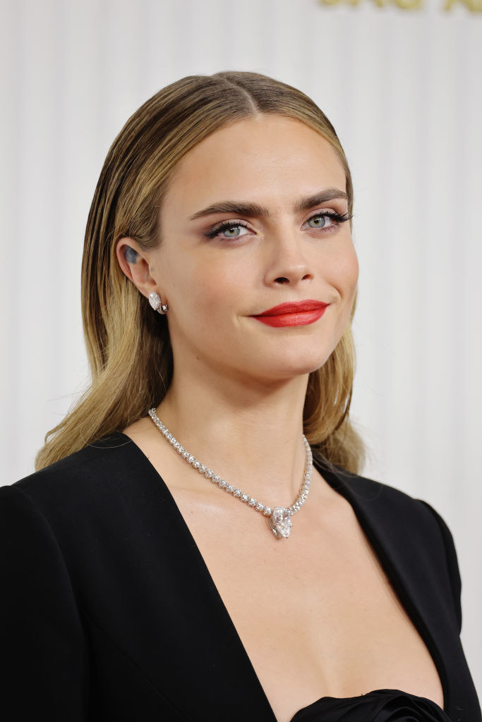 Close-up of Cara smiling and showing her necklace