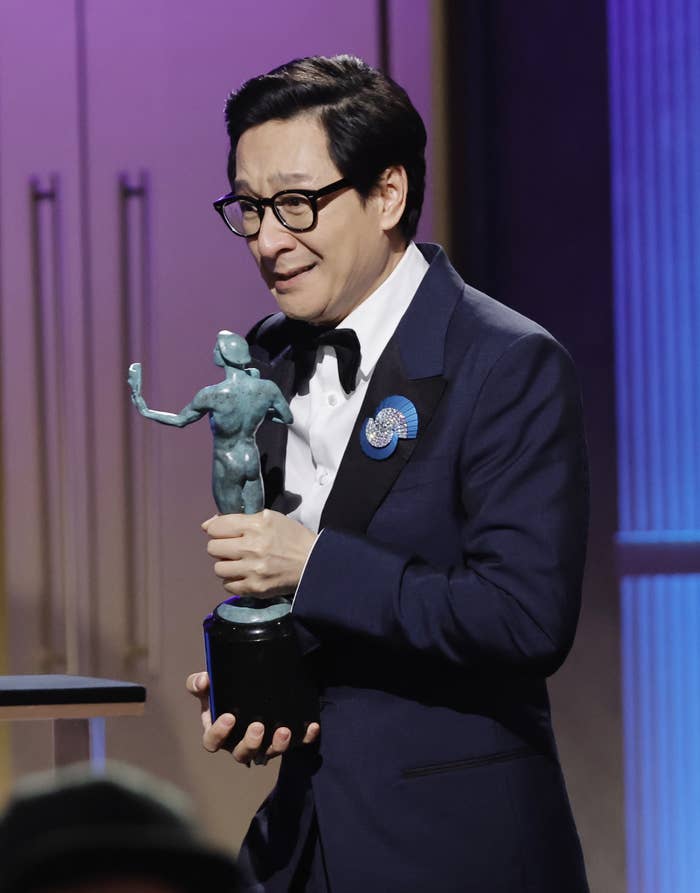 Ke Huy Quan holding his SAG award