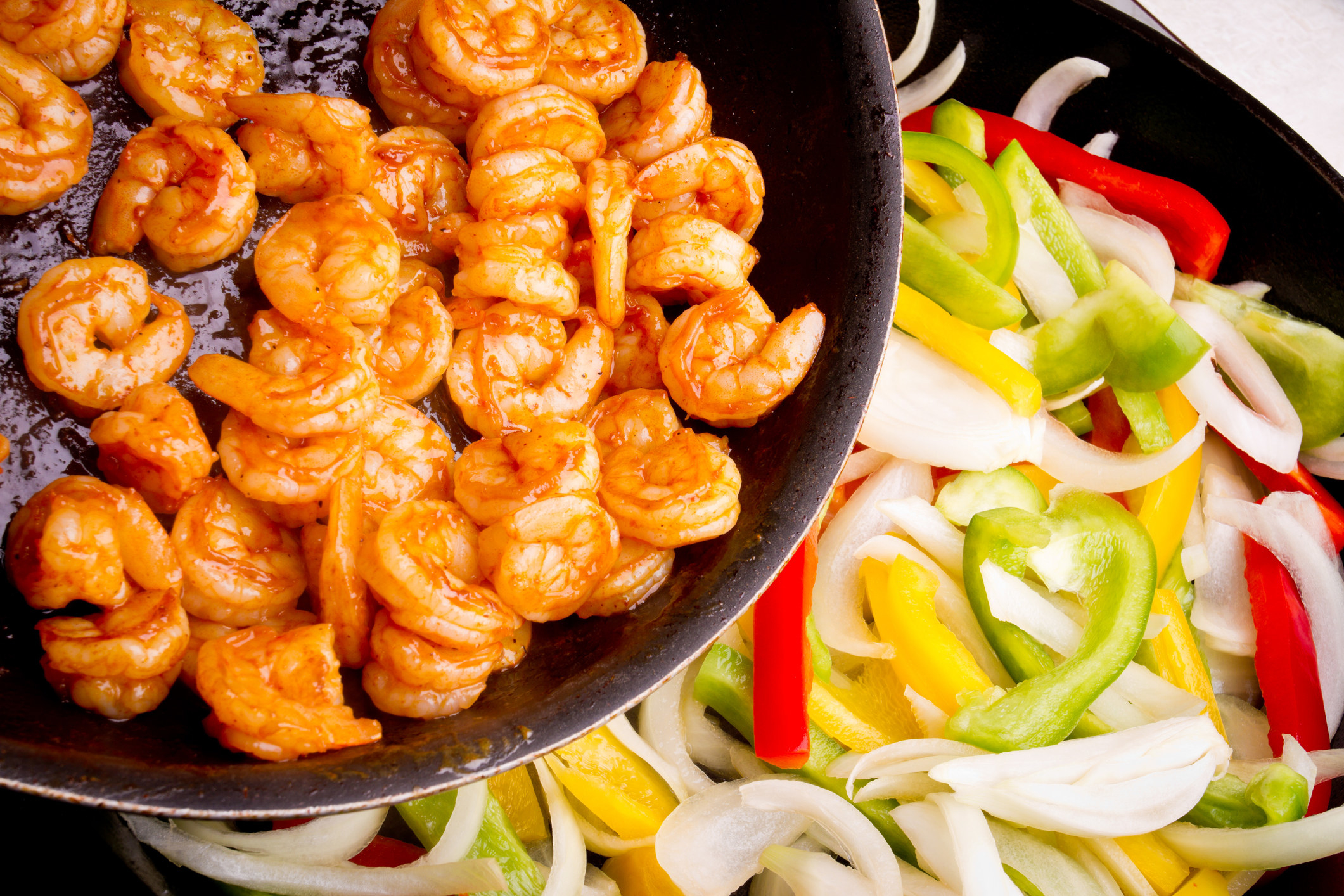 Shrimp Fajitas on a hot skillet with onions, peppers.