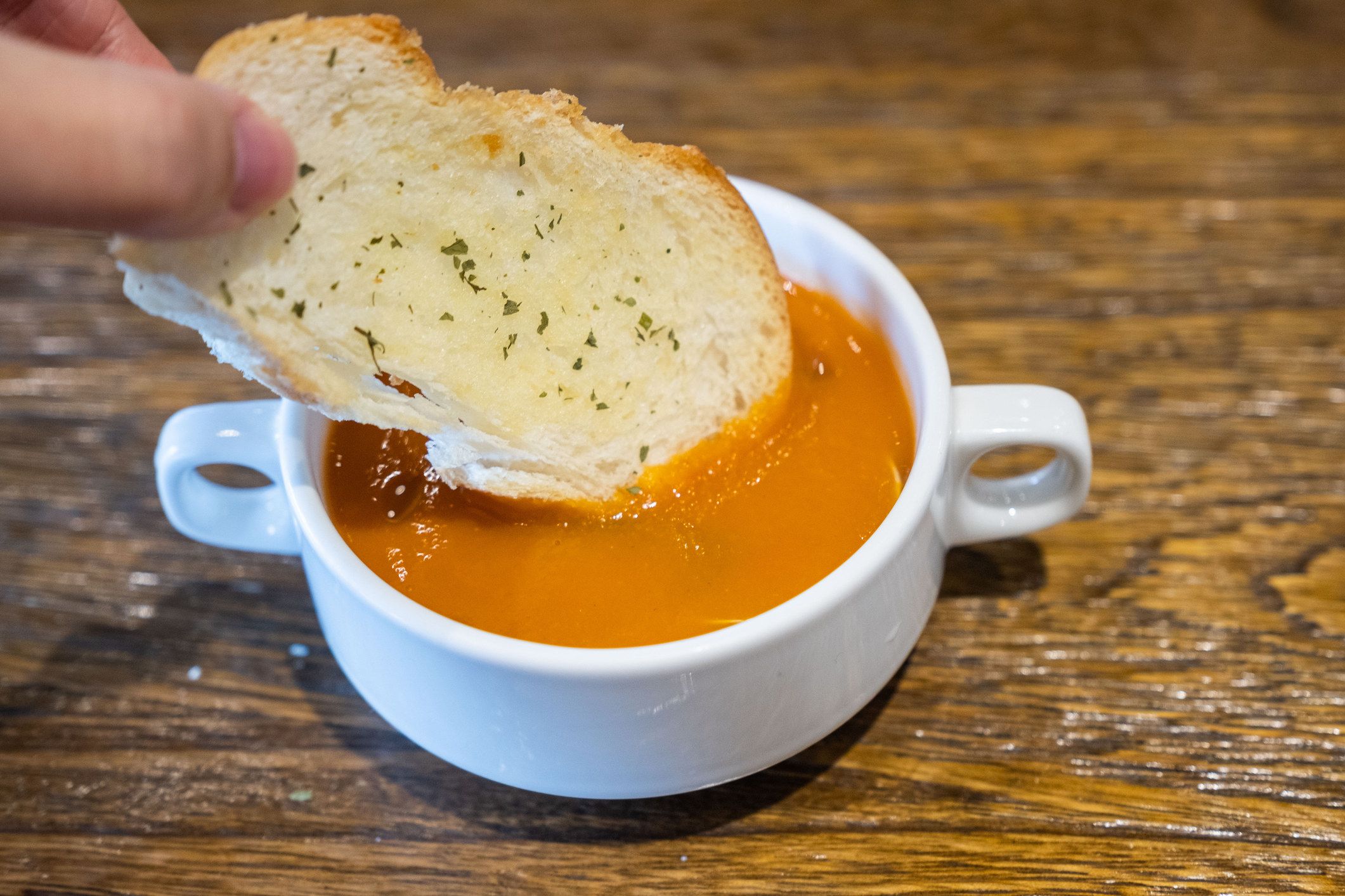 Roasted tomato soup with a slice of bread.
