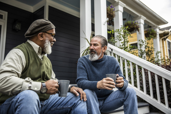 Two men talking on the porch steps