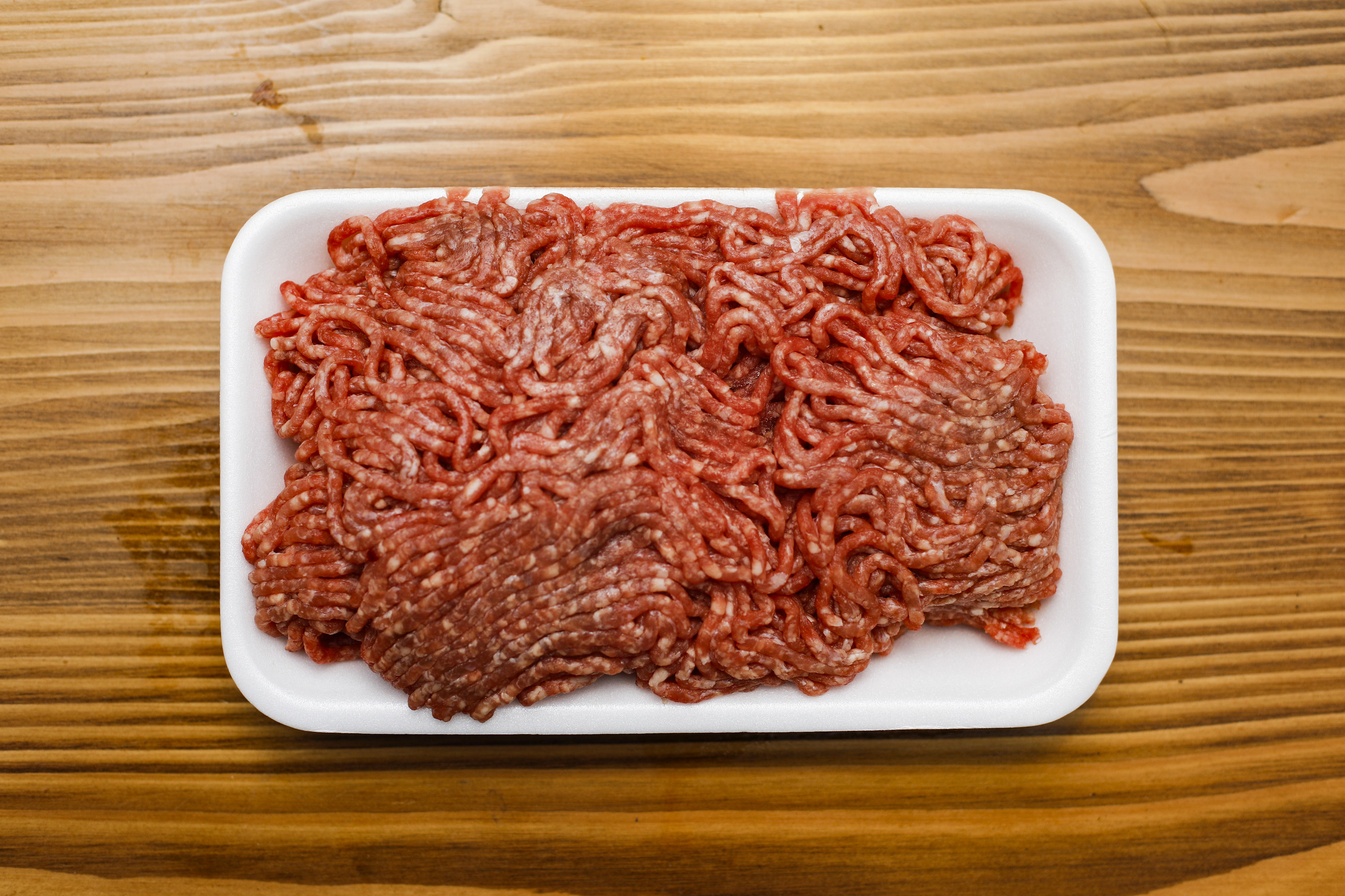 A detail of ground beef on the wooden table