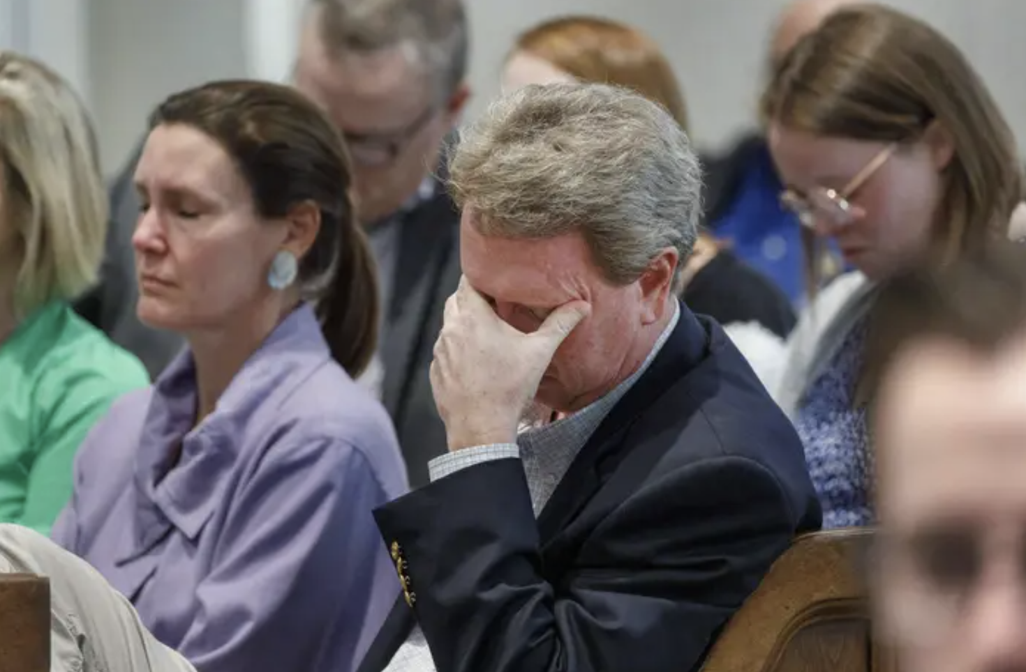 John Marvin Murdaug covering his face with his hand in a crowded courtroom