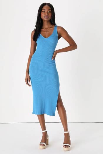 Model wearing blue dress with white and tan shoes