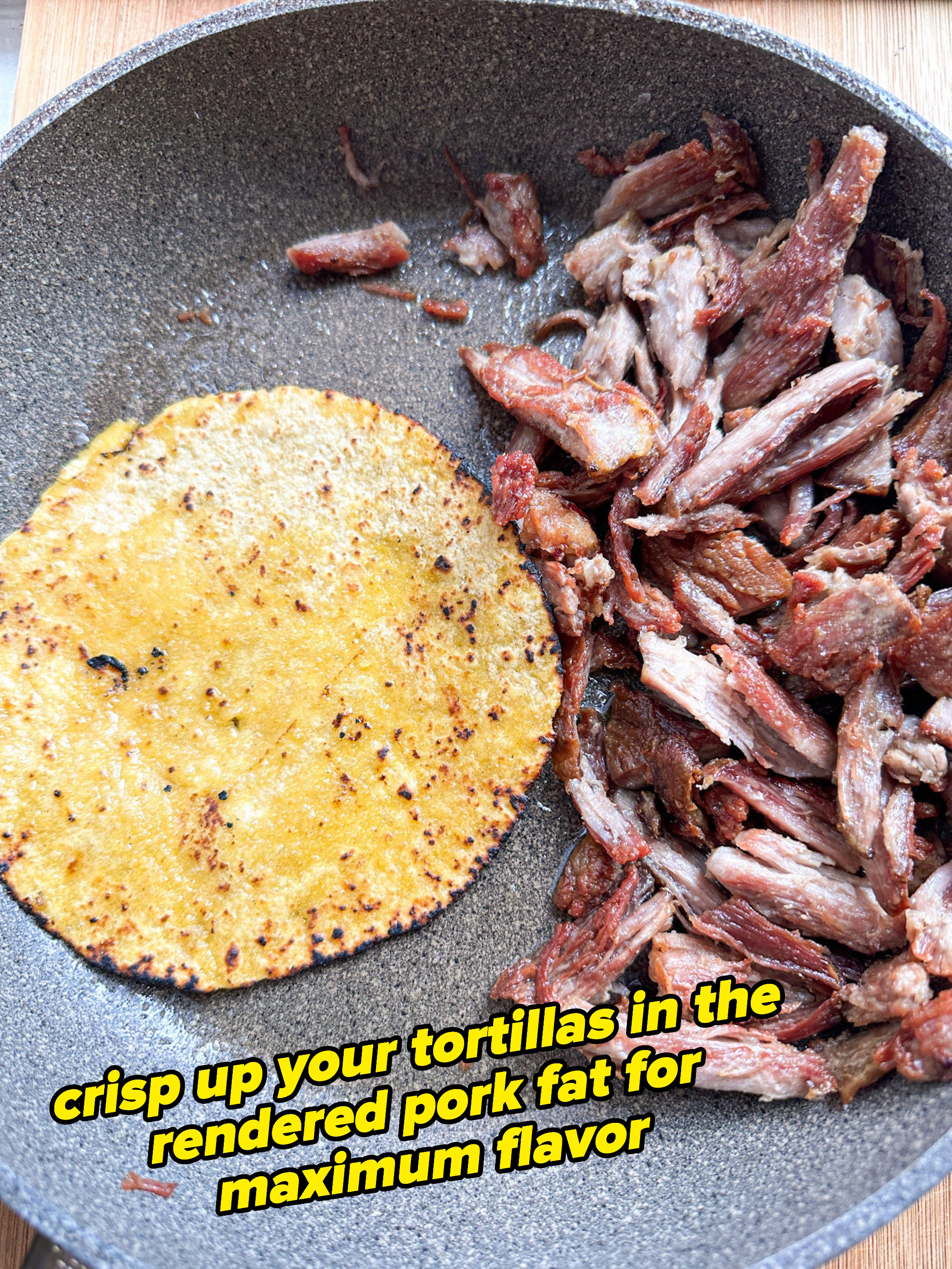 shredded pork next to a crispy tortilla in the skillet