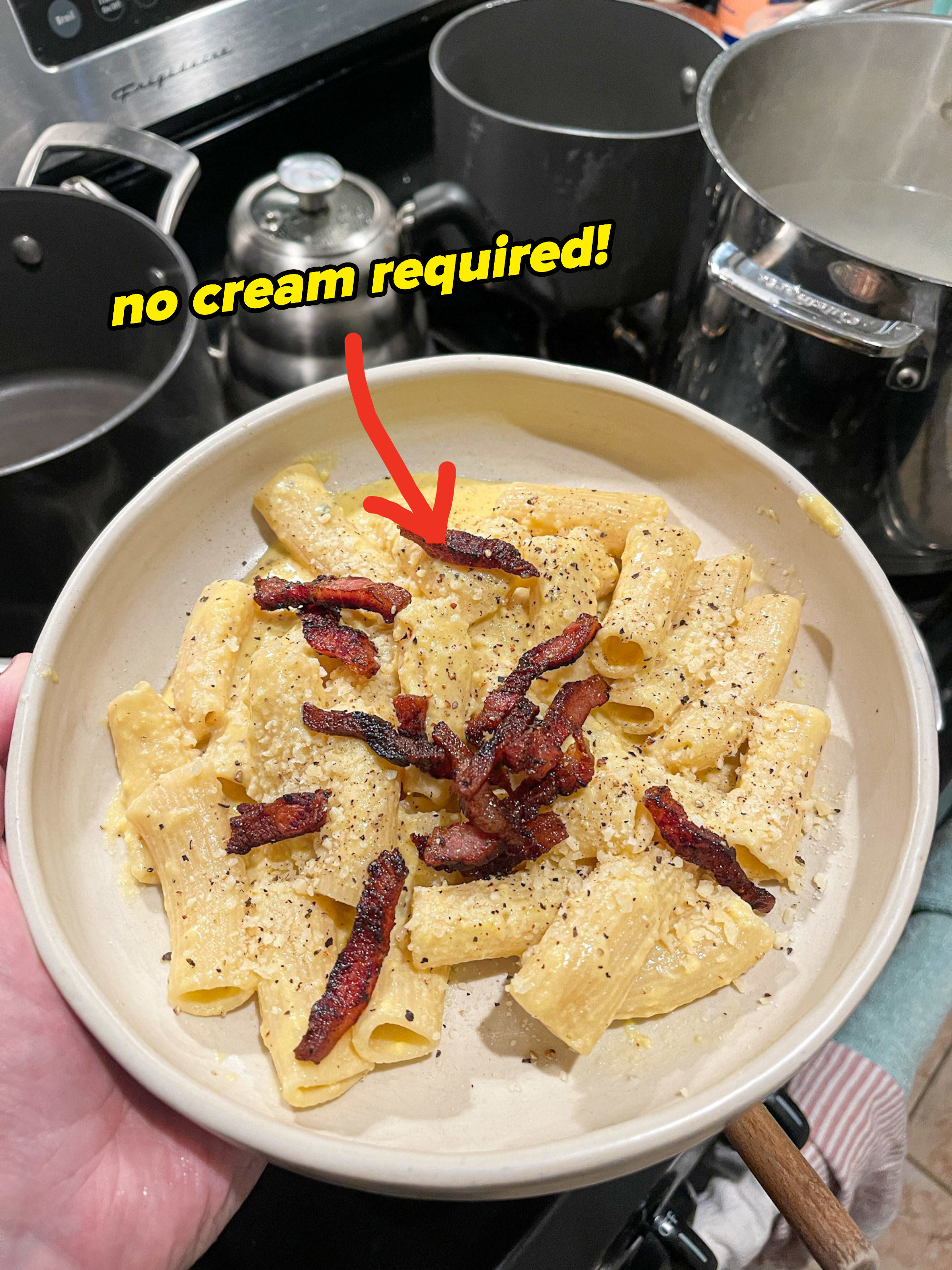 creamy looking carbonara topped with crispy guanciale and parmesan cheese
