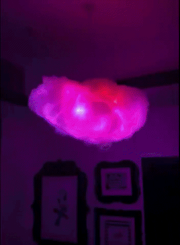 a gif of a fluffy cloud light hanging from a ceiling changing colours