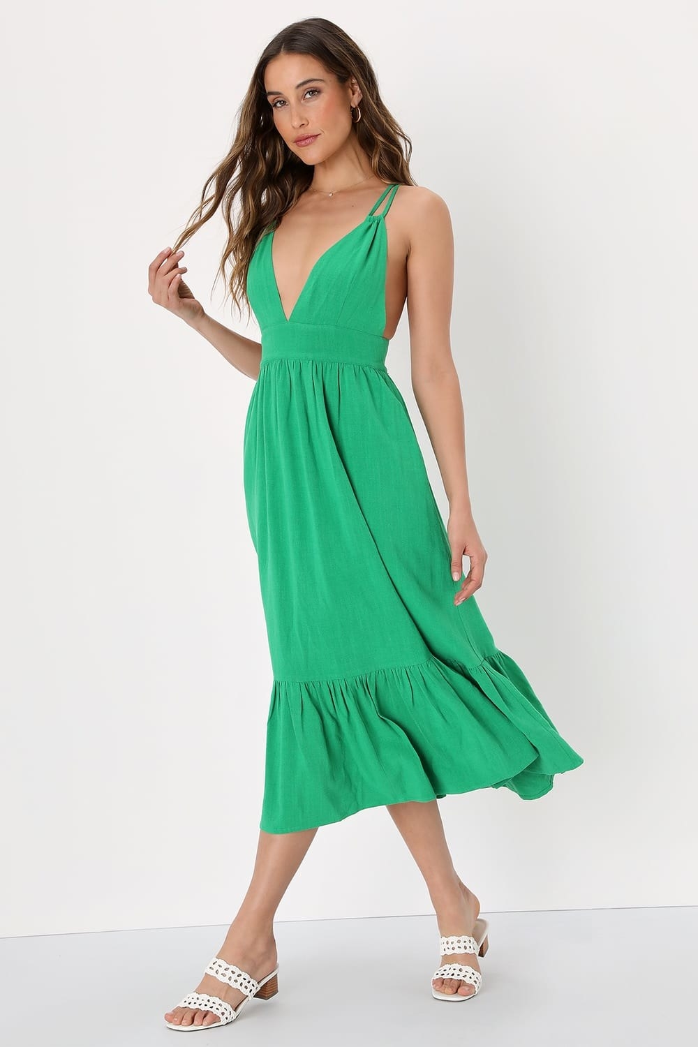 Model wearing green dress and white sandals