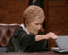 Judge Judy looking at a laptop in disgust and closing it