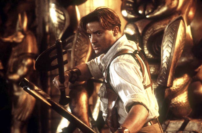 Brendan holding two weapons while in a fighting stance in a scene from The Mummy