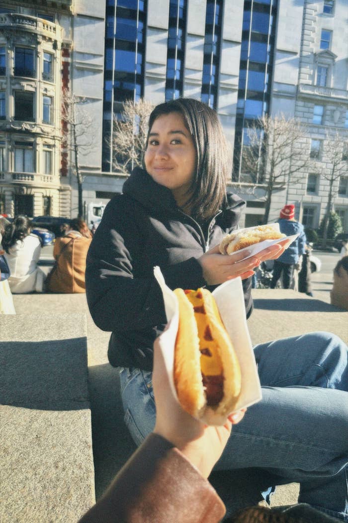 the author eating food outside as they sit on steps