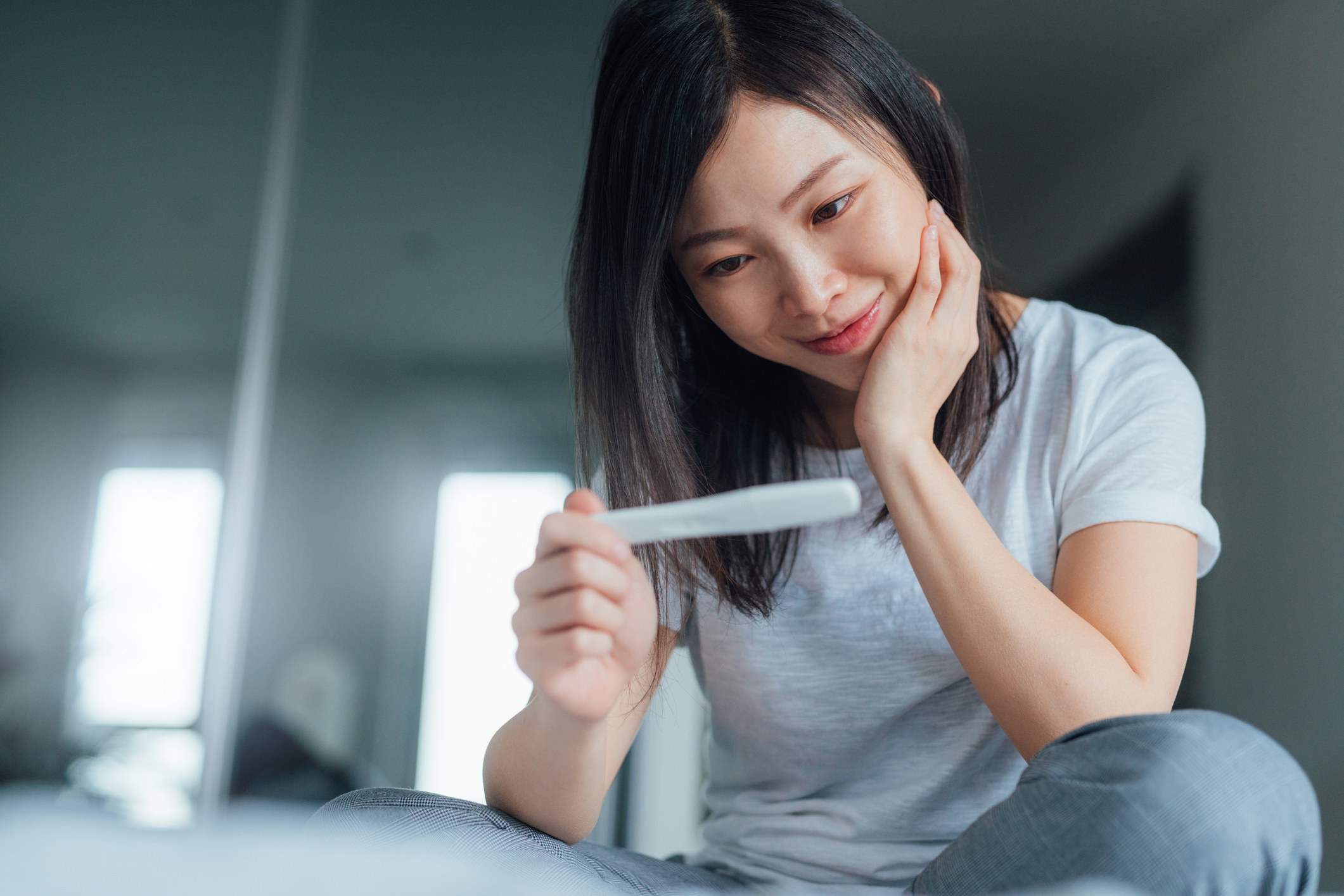 A woman looking at a pregnancy test