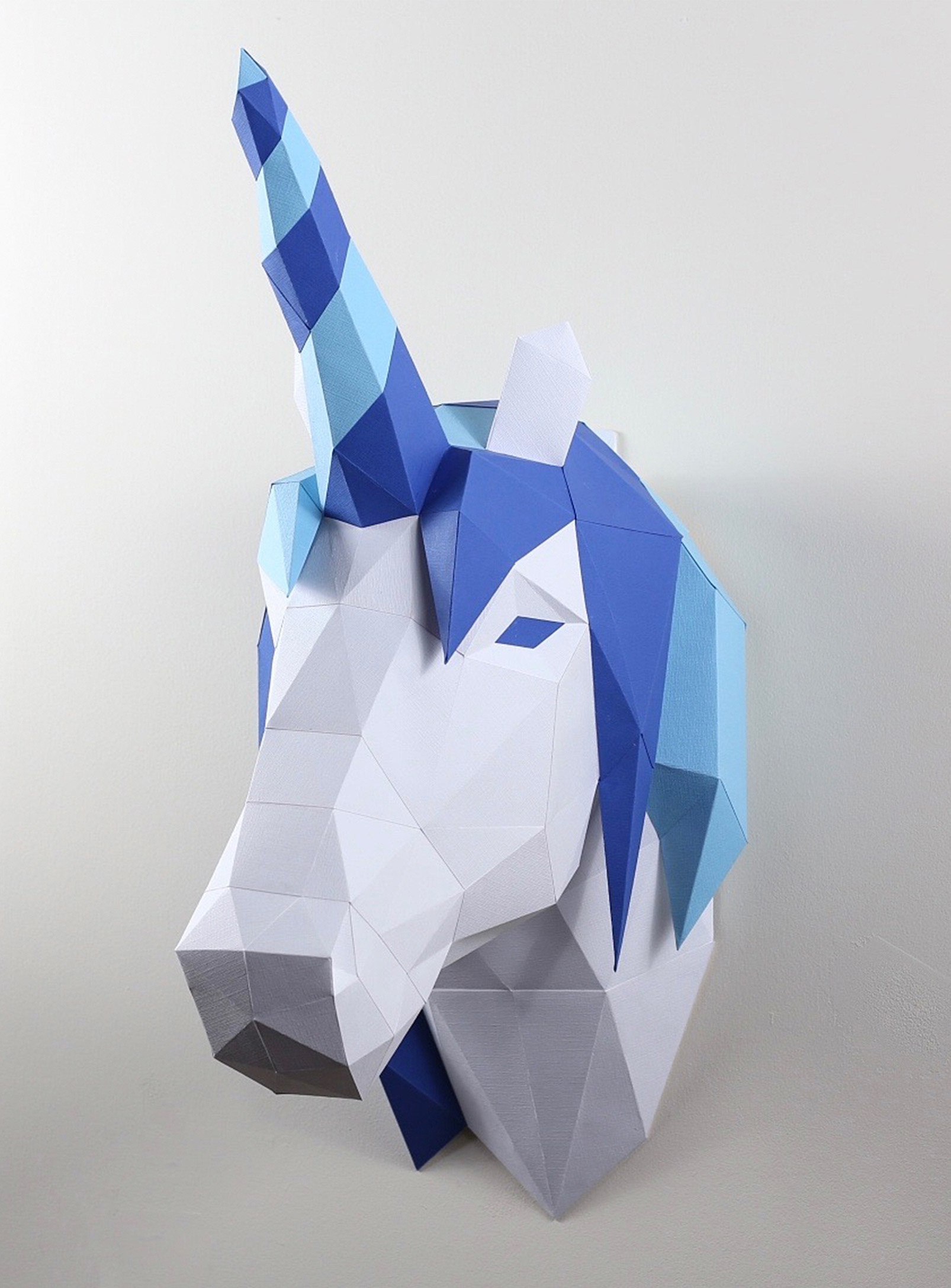 a 3D paper puzzle of a unicorn mounted on the wall