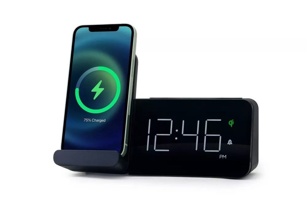 The alarm clock with the time and charging a phone
