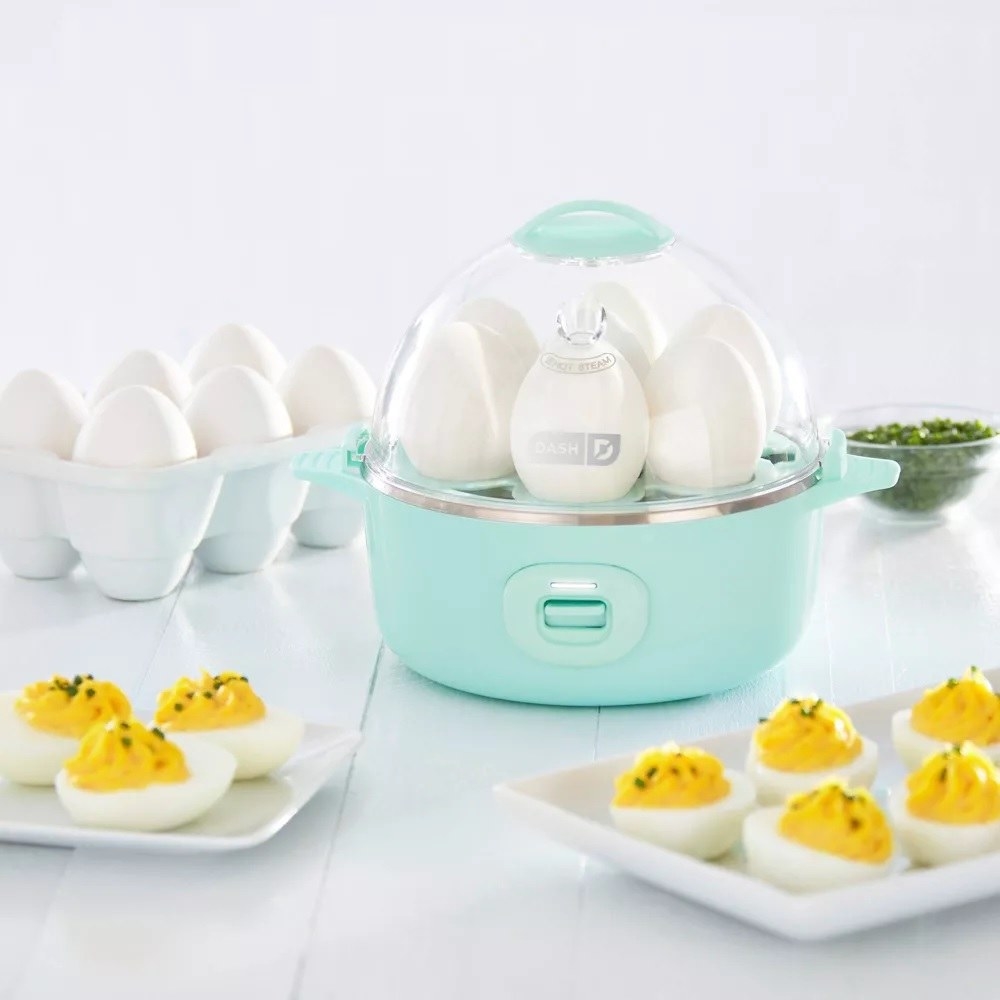 The egg cooker surrounded by deviled eggs