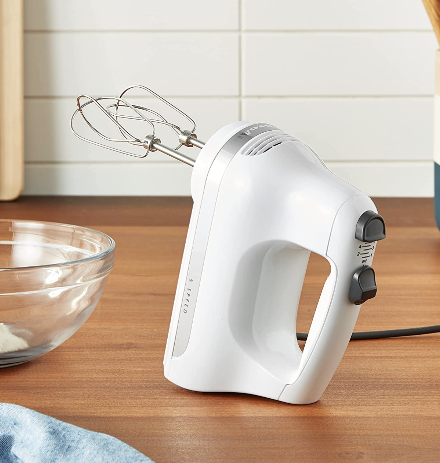 the hand mixer standing up on a wooden countertop