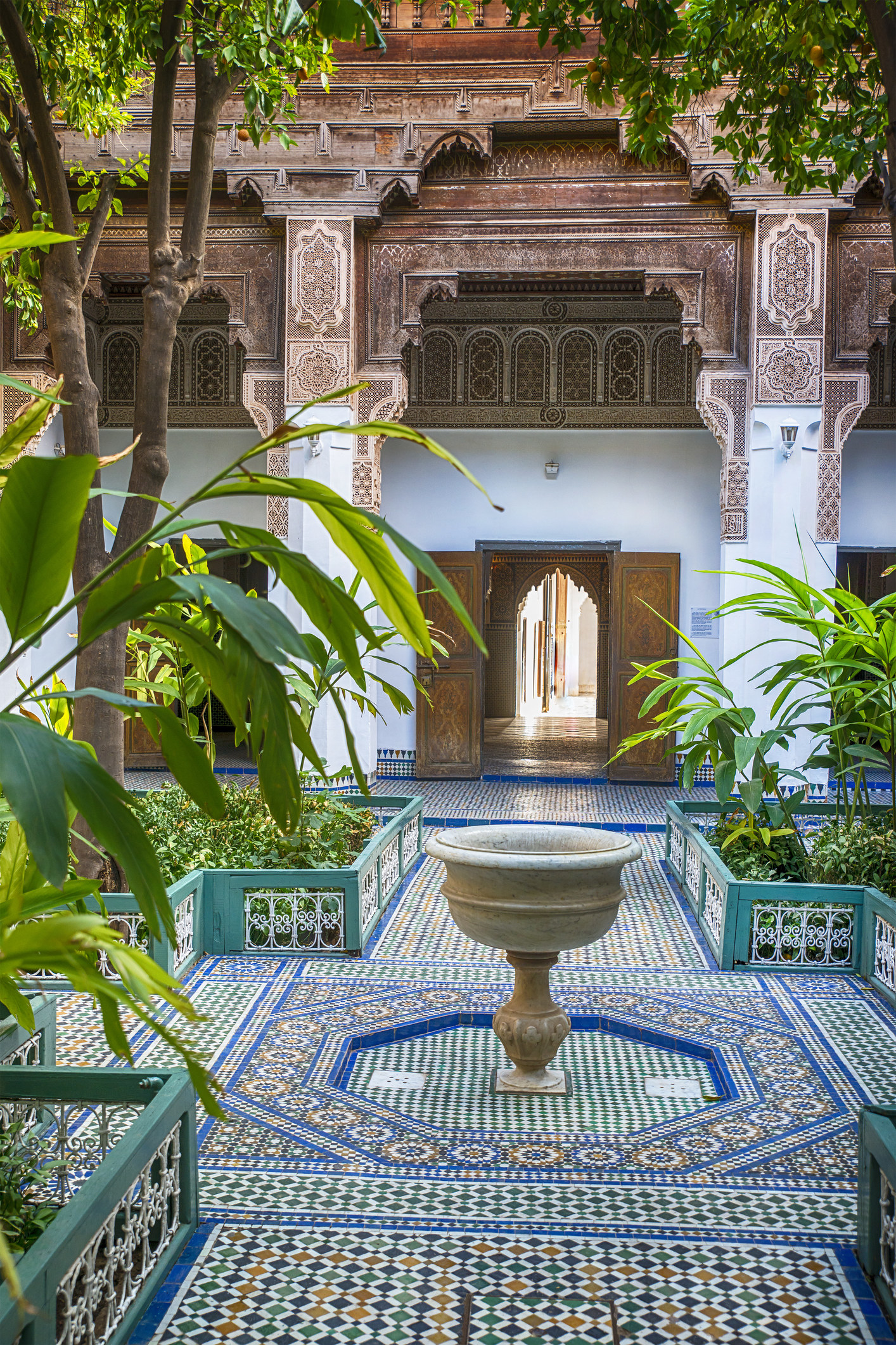 A courtyard in Morocco with tiles and a fountain.