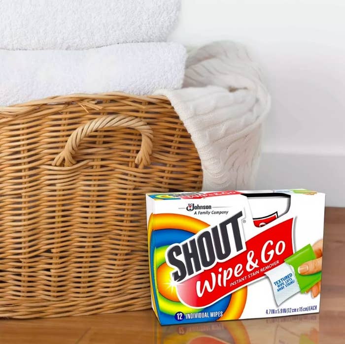 Box of stain remover wipes next to a basket of laundry