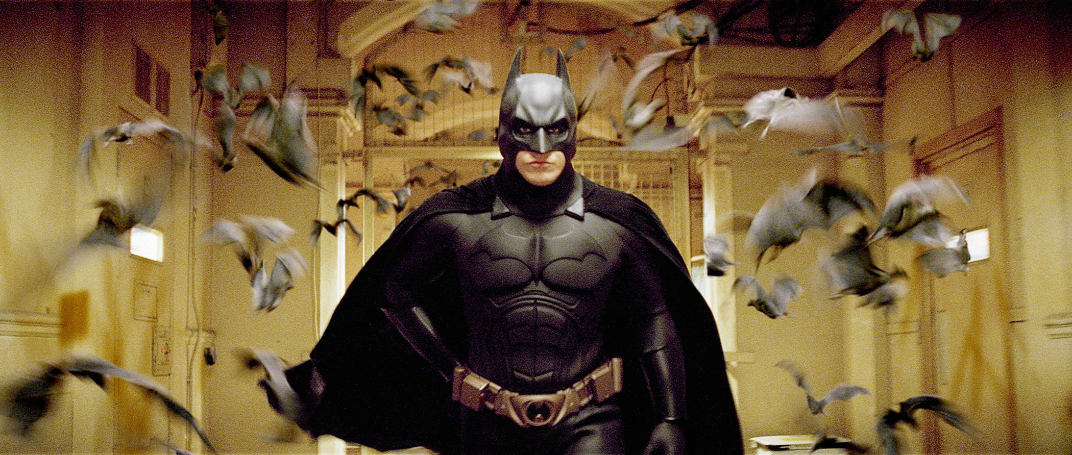 Christian Bale as Batman, surrounded by bats