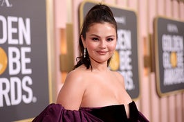 Selena Gomez smiles at cameras without showing teeth.