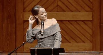 Rihanna twirls her hair during a speech accepting the Harvard Humanitarian of the Year award