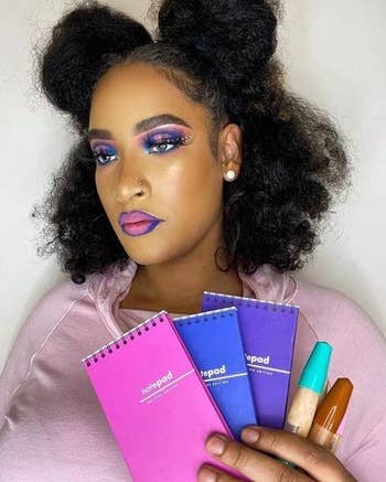 a model holding up the pink, blue, and purple palettes