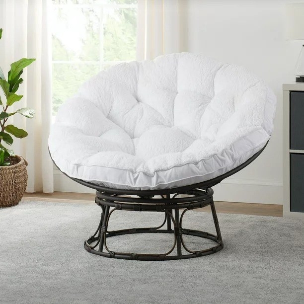 A white Papasan chair resting on gray carpet.