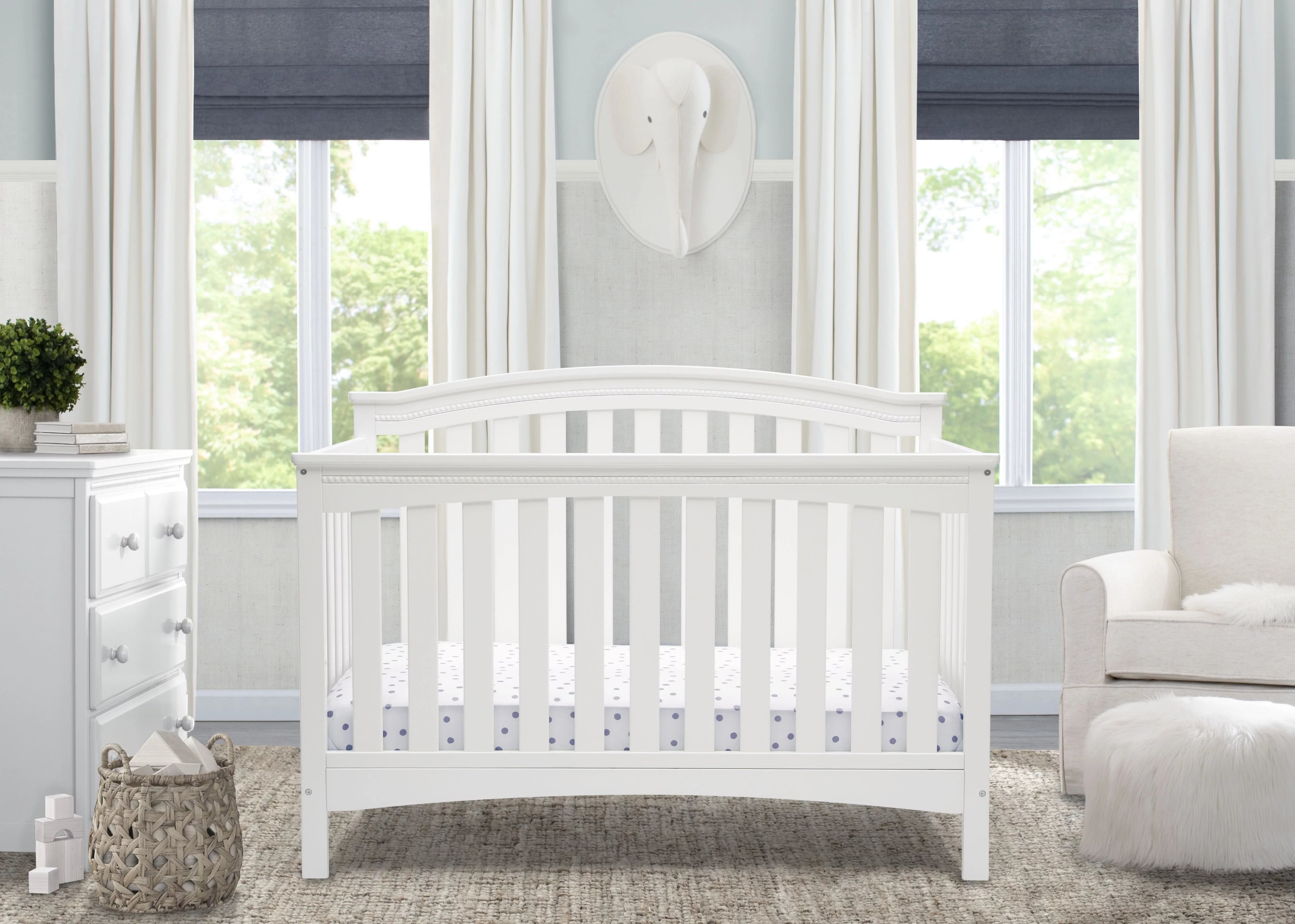A white convertible crib in a nursery bedroom