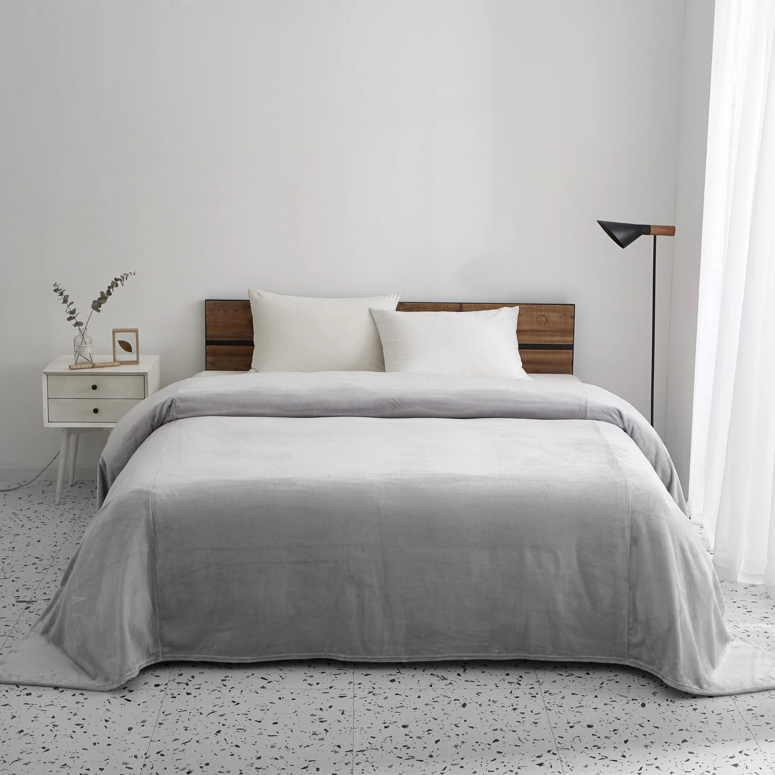 A fleece blanket spread on a bed in a bedroom
