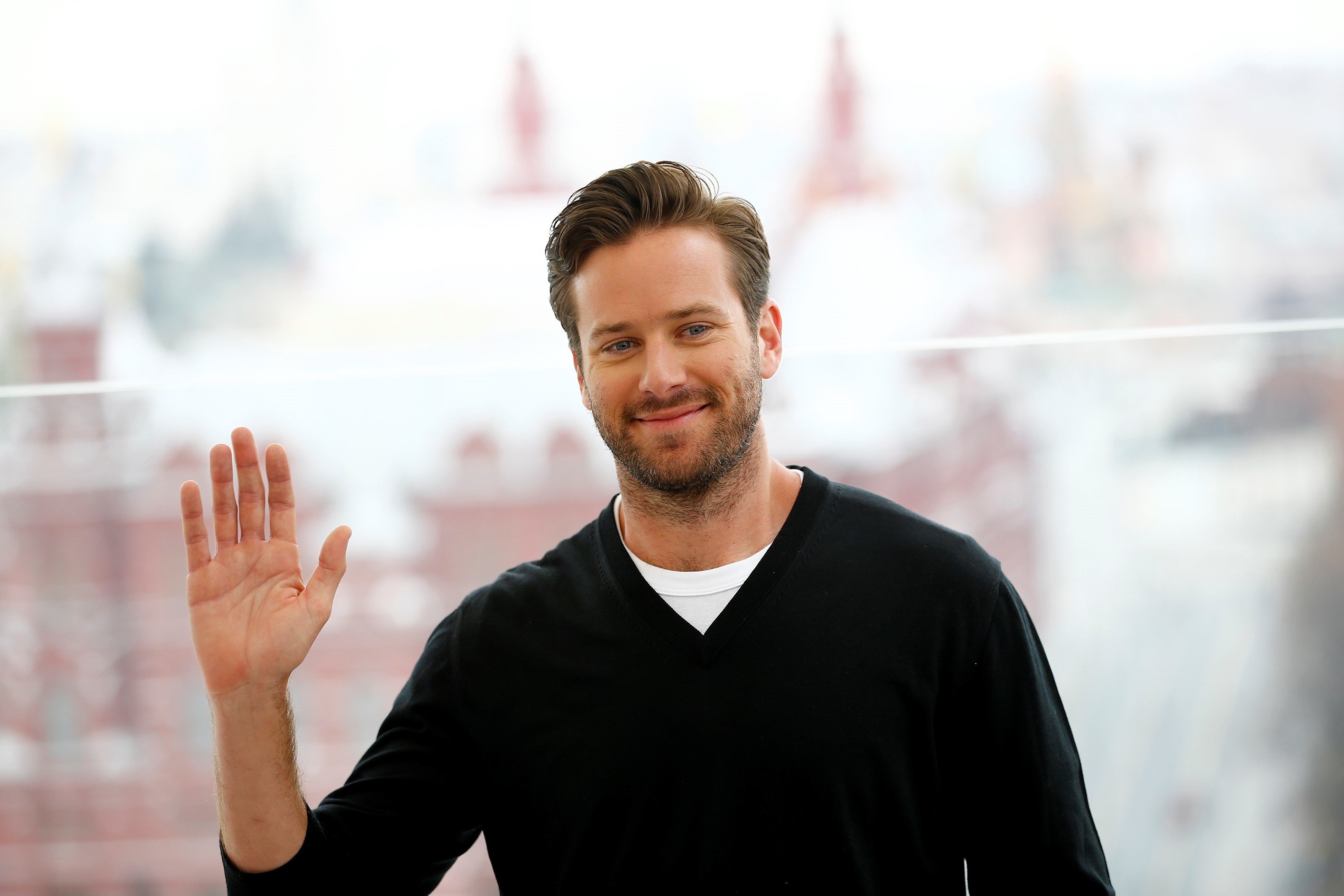 Armie with his hand raised