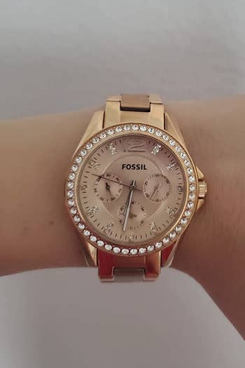 A reviewer wearing the rose gold watch