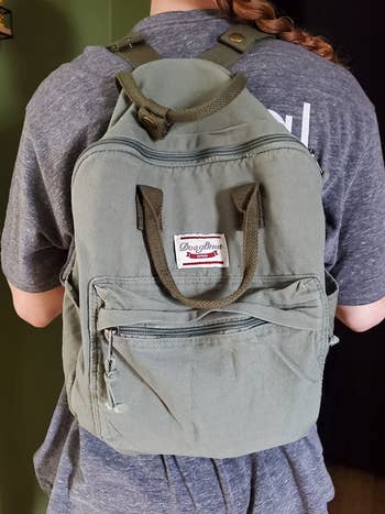a reviewer wearing the army green bag
