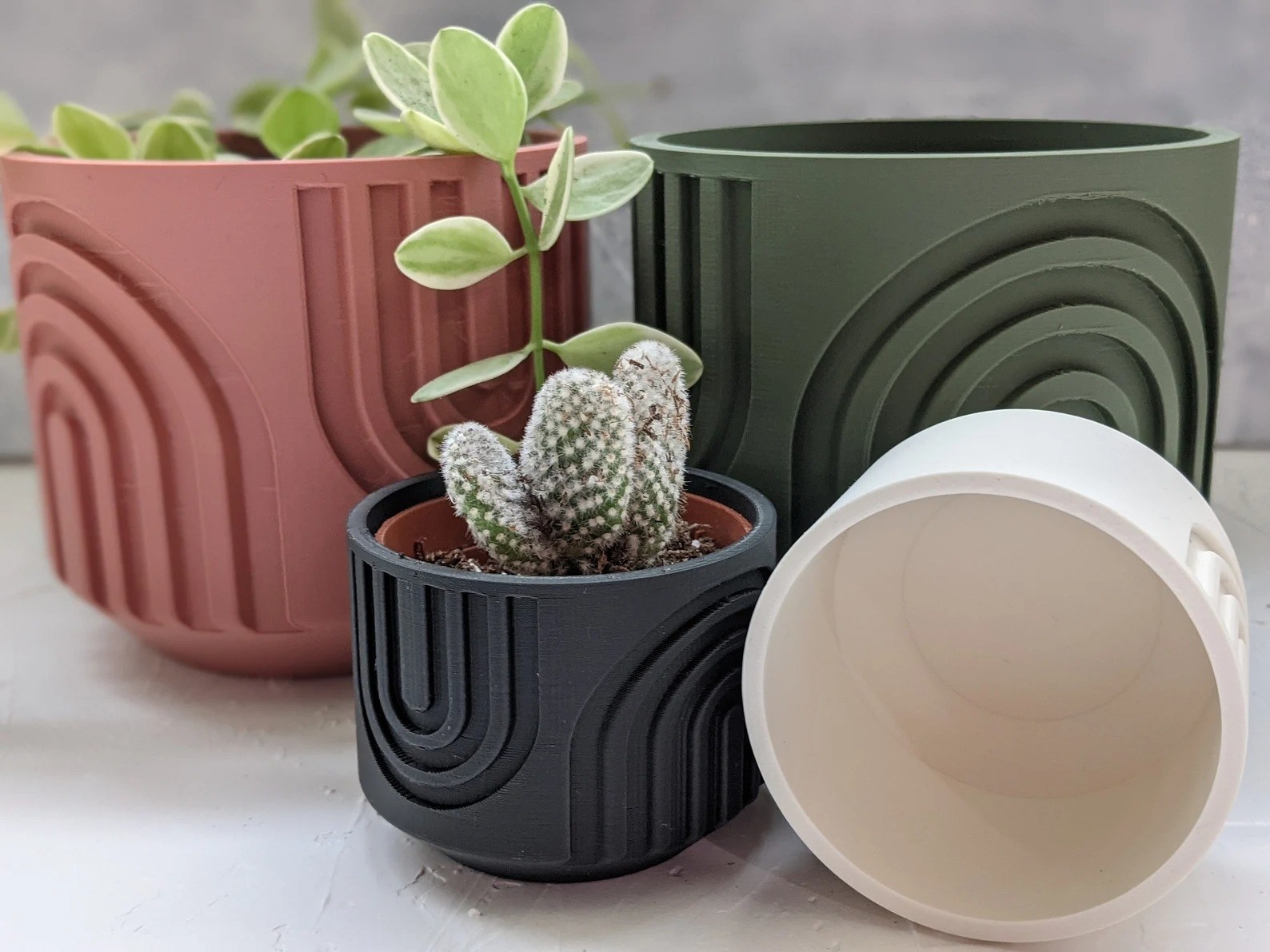 A collection of four colorful planters is shown