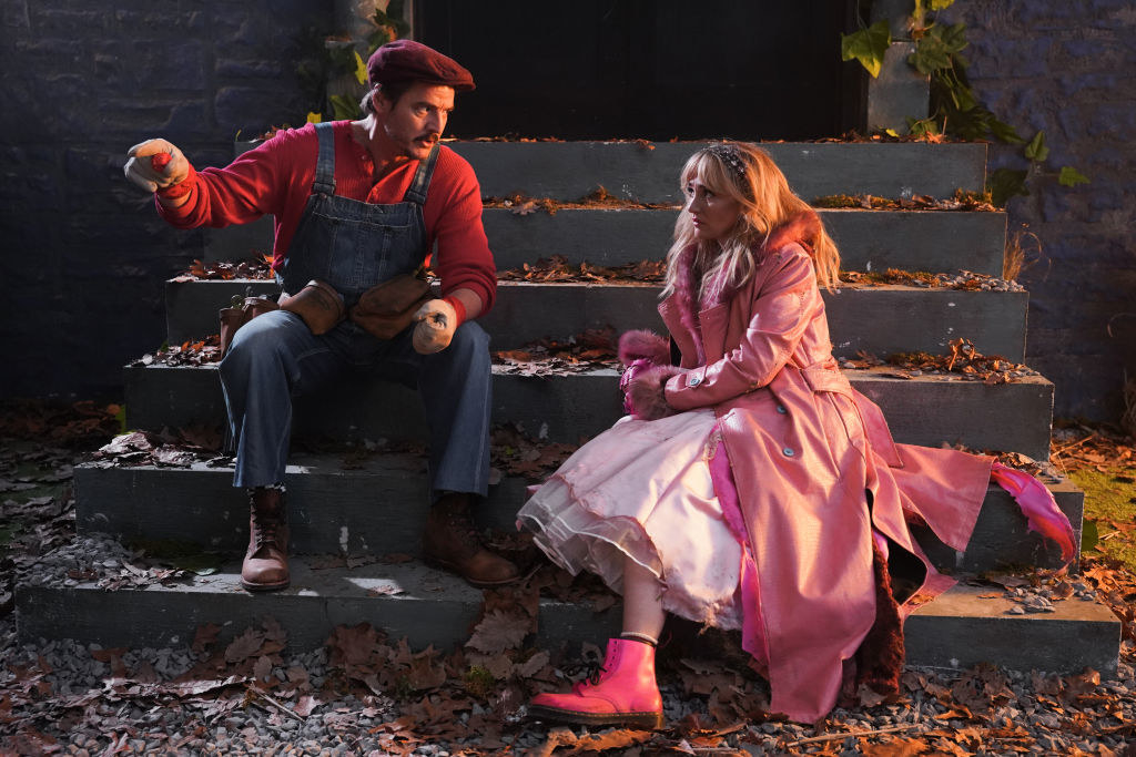 Pedro Pascal as Mario and Chloe Fineman as Princess Peach sitting on steps and talking
