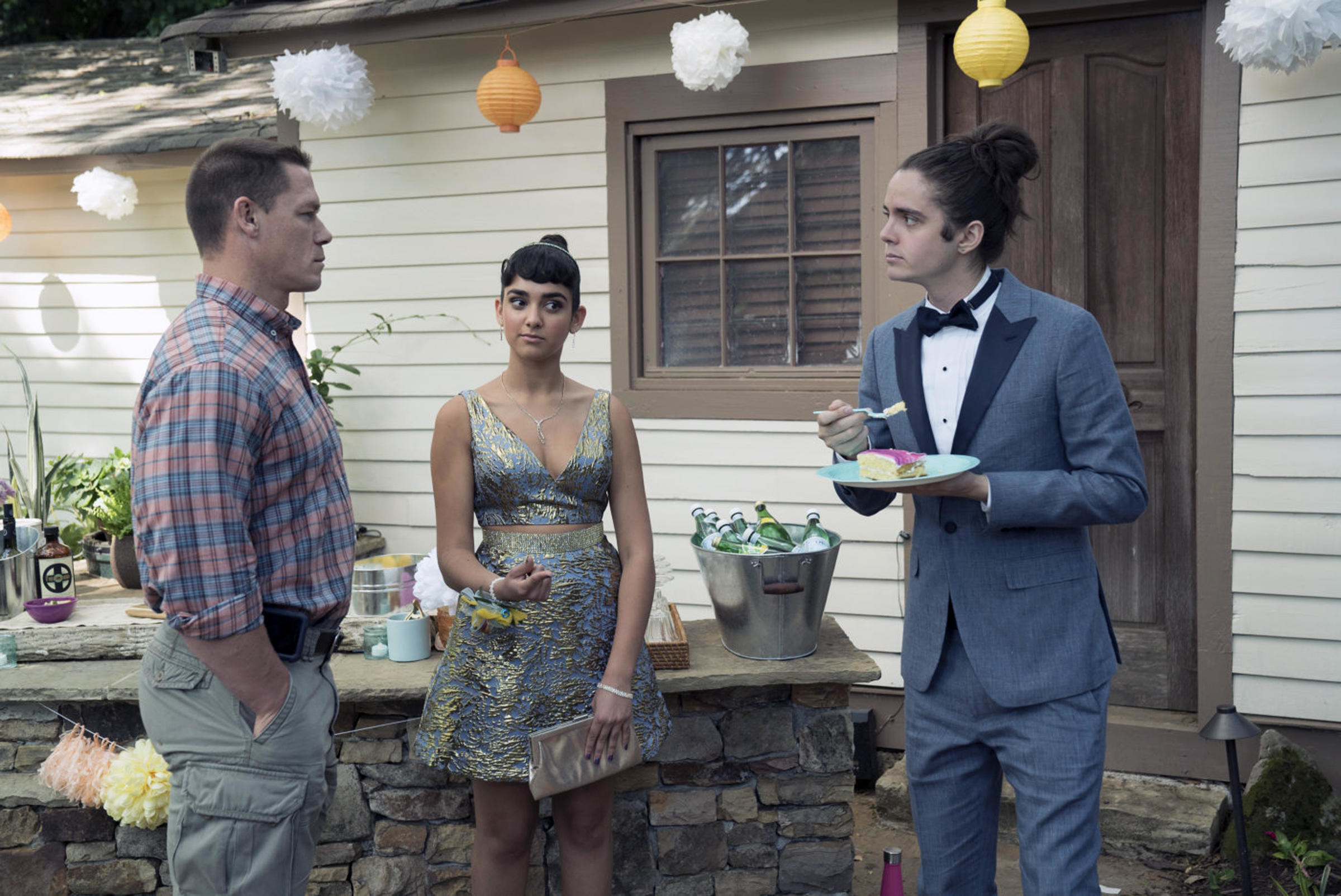 A stern father talks to his daughter&#x27;s prom date as he eats cake