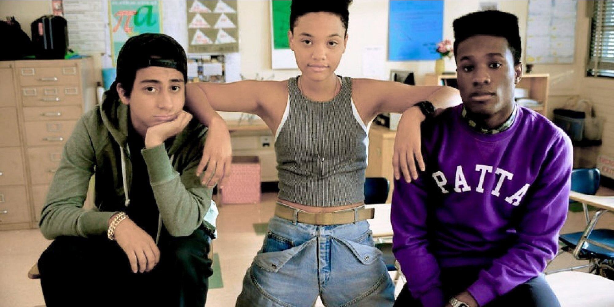 A trio of high school students pose in a classroom