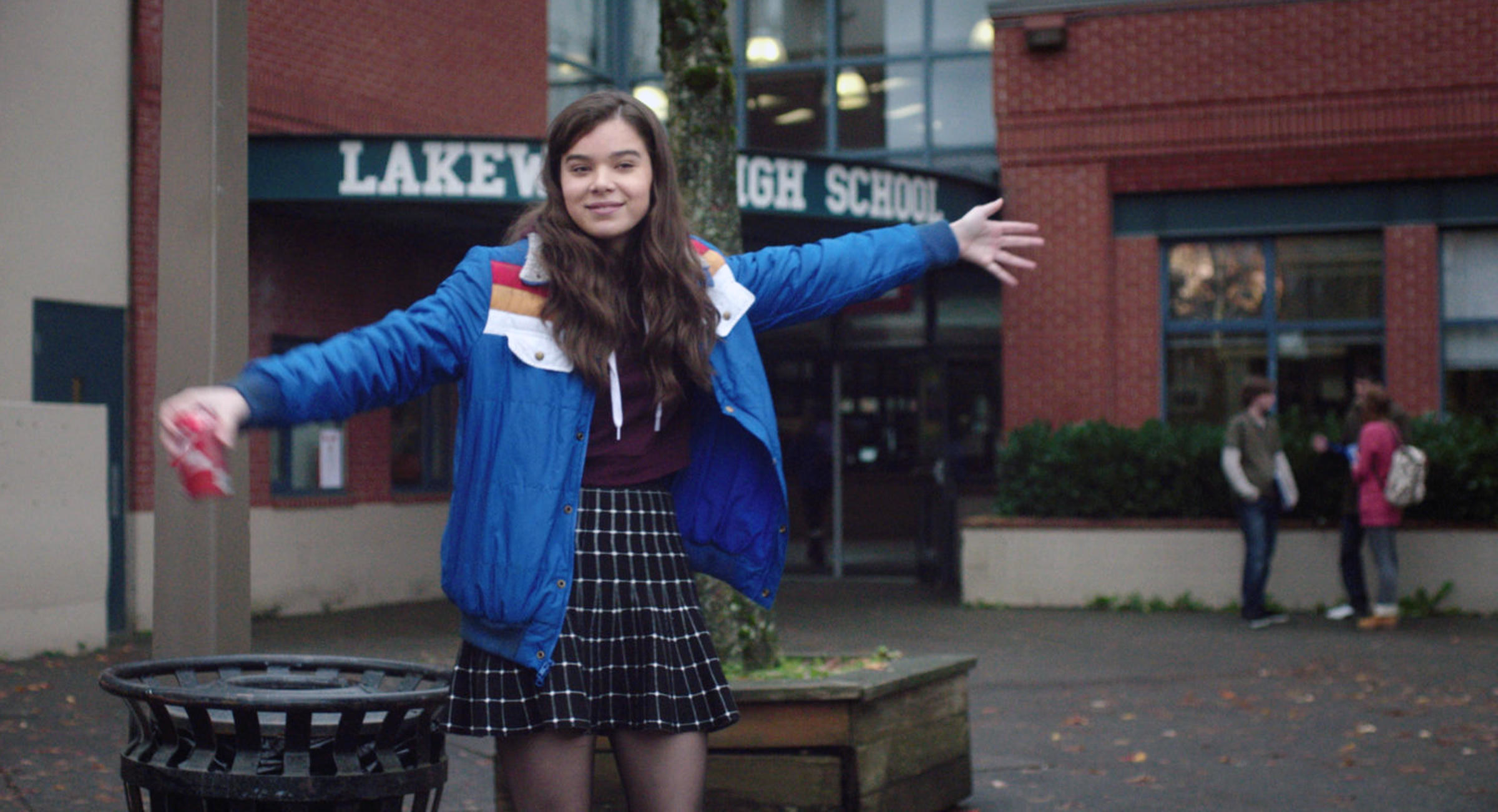 A teenage girl poses in front of her high school