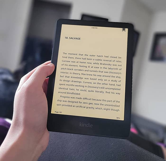 Reviewer holding kindle paperwhite with book on display