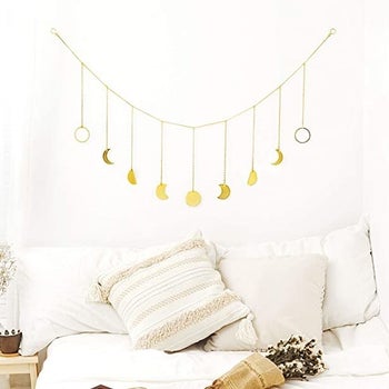 The moon cycle garland is hanging on the all over a bed