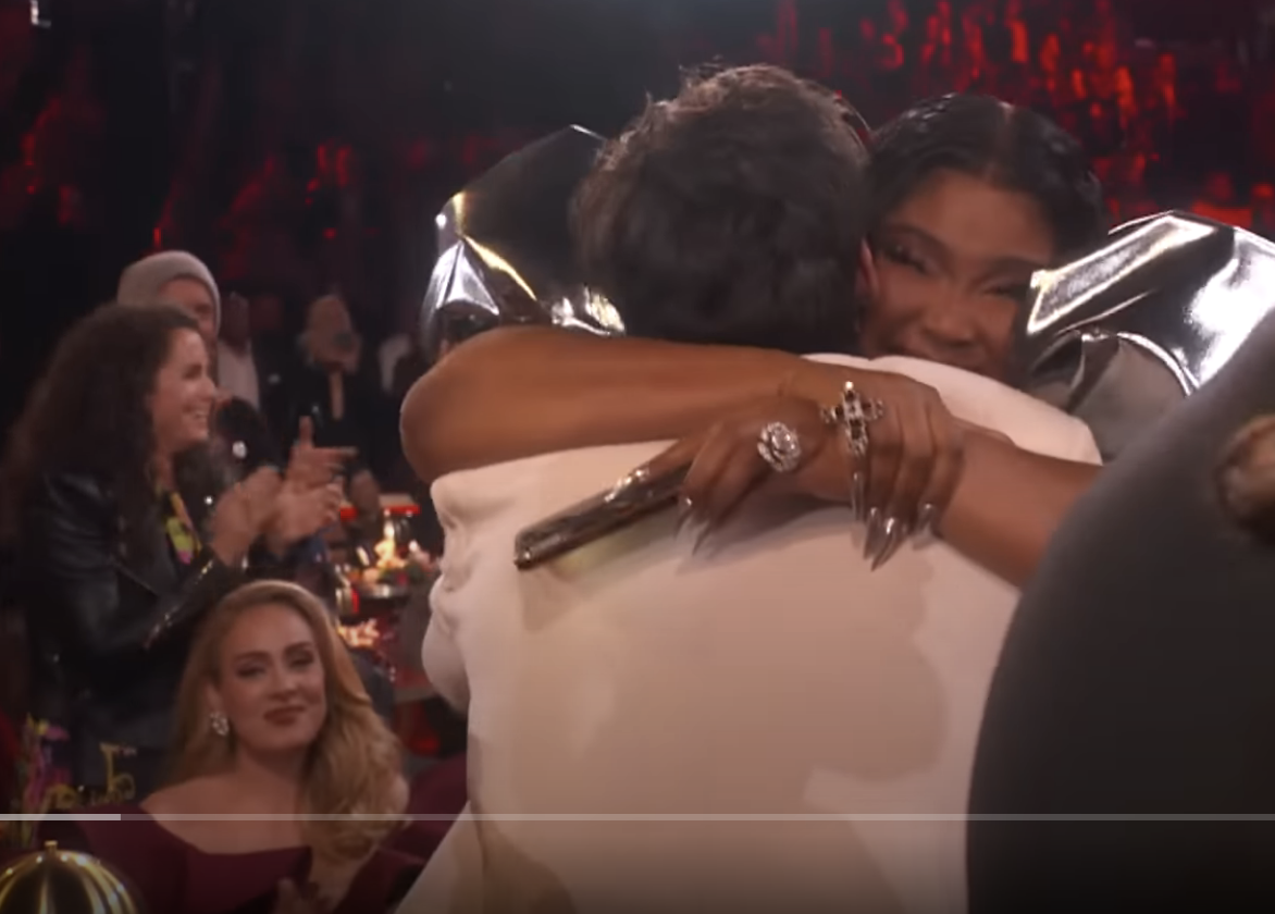 Adele looks on as Lizzo hugs Harry