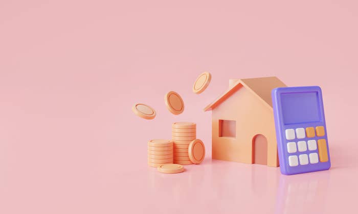 A miniature abstract rendering of a home with a calculator leaning against it and a stack of coins on the other side