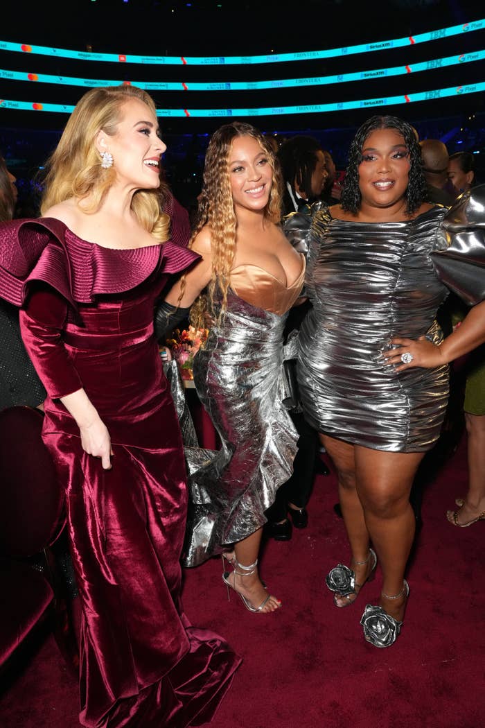 Adele and Lizzo smile as they pose for a picture with Beyoncé in the middle