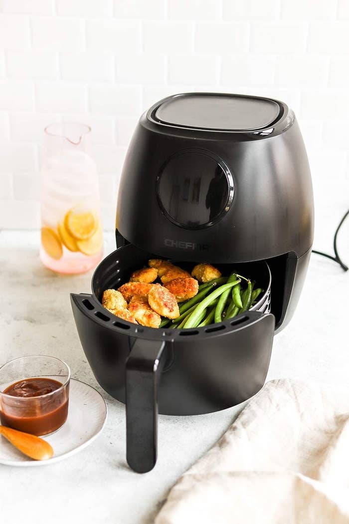 the air fryer with some chicken nuggets and beans in it
