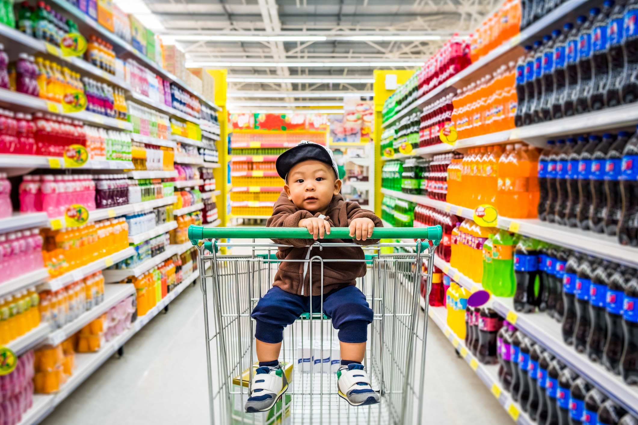 A toddler in a grocery cart at the supermarket