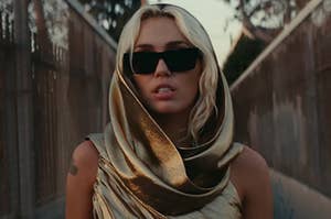 Miley Cyrus wearing sunglasses and a silk scarf over her head in the Flowers music video