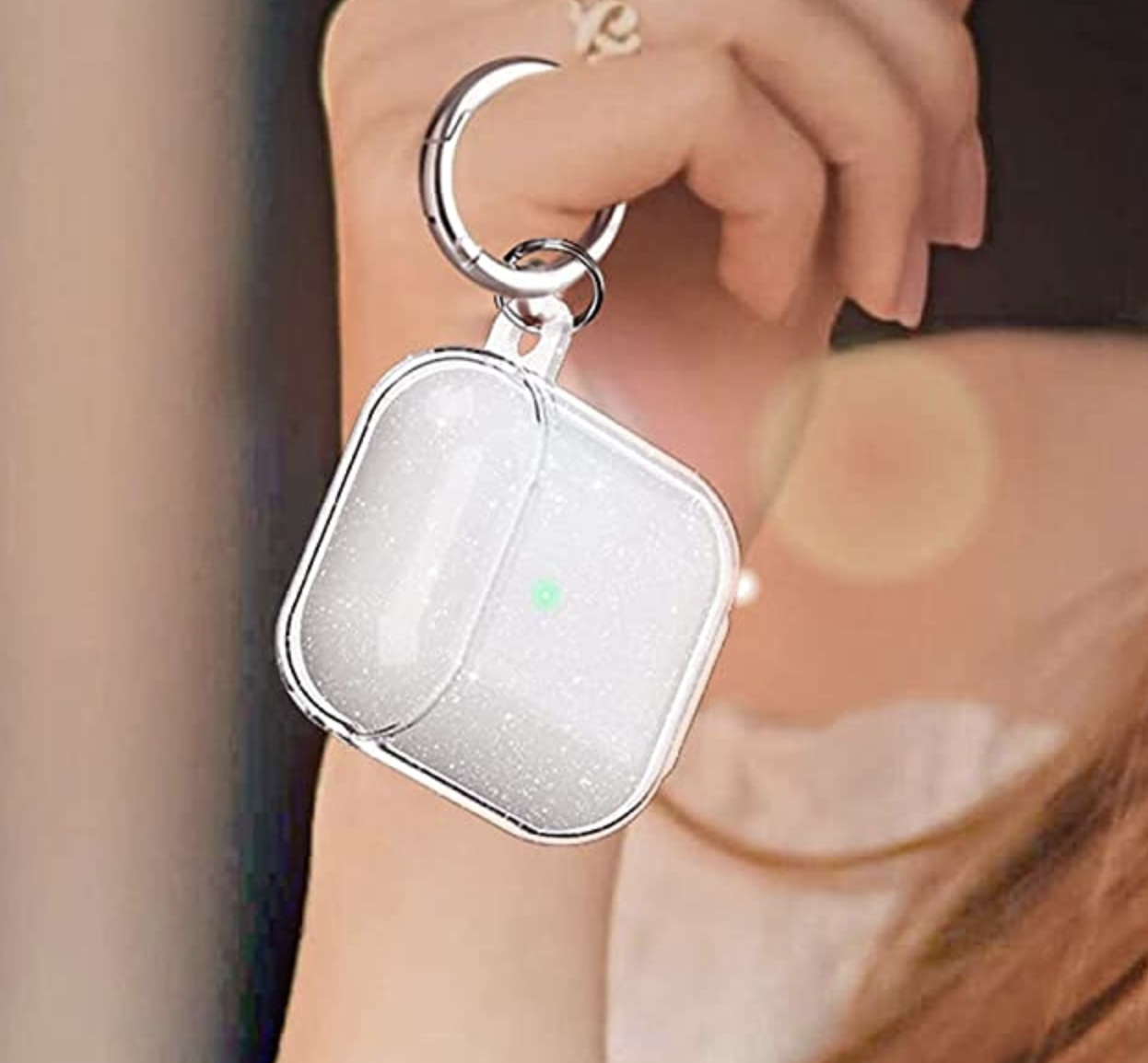 a person holding up the AirPods in the case