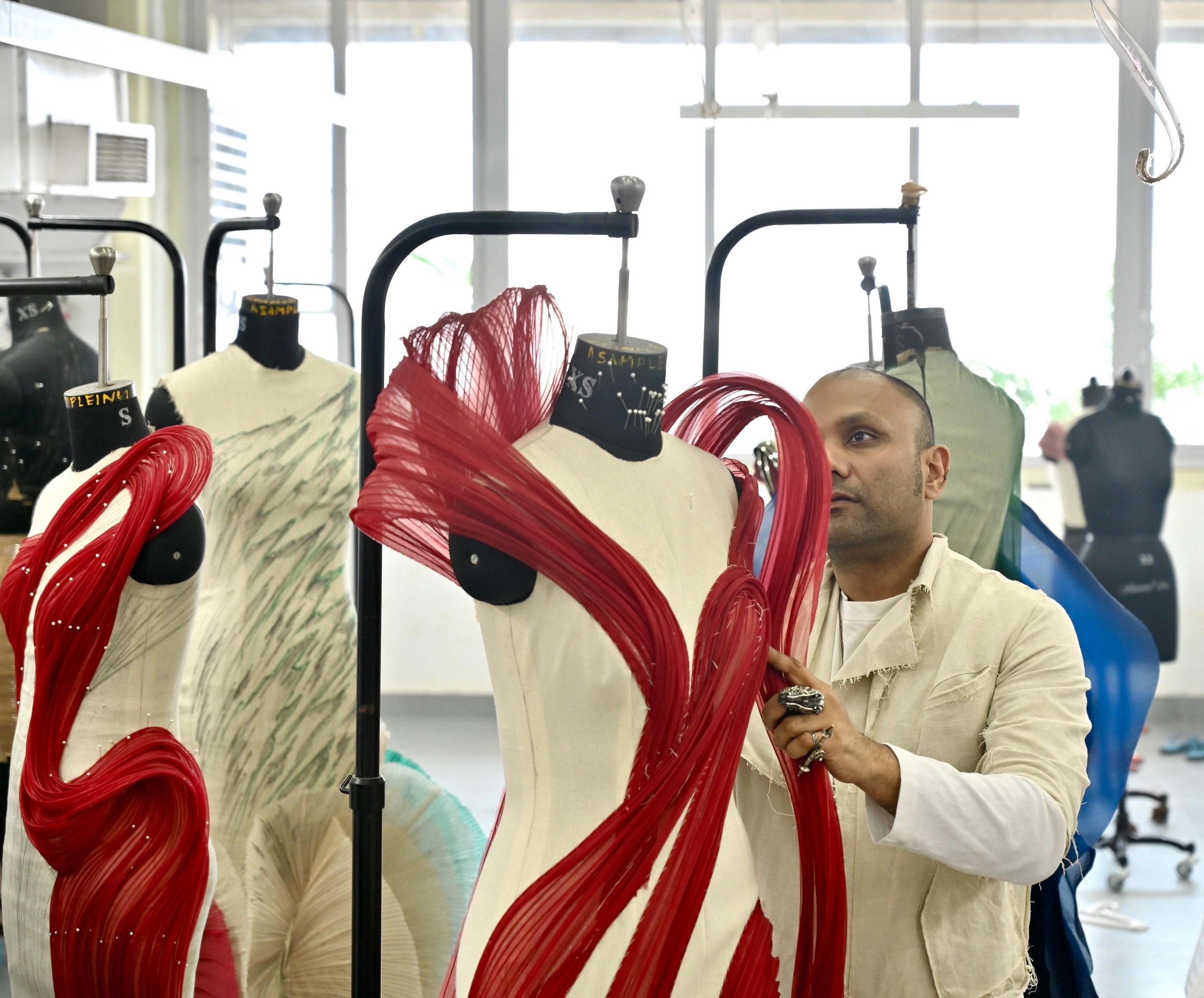 Couturier Gaurav Gupta works on a a dress on a form in his studio