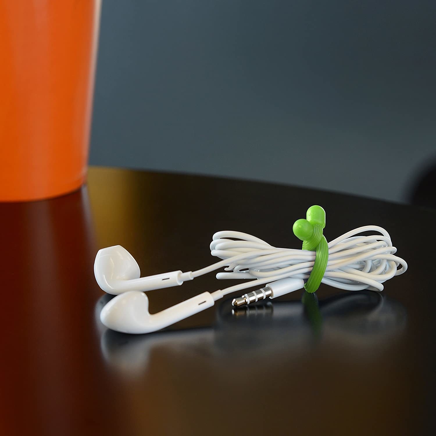 a pair of corded earbuds neatly wound up and held together with a reusable twist tie