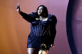 Lizzo holds up a finger while the crowd cheers during a performance
